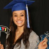 soon to be graduate takes a fun picture with photobooth props